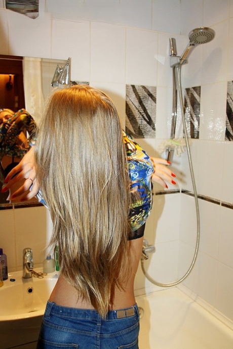 Стройная любительница обнажает свои маленькие сиськи в синих джинсах во время домашнего действа 12