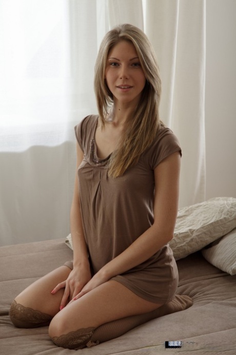 Худенькая блондинка раздвигает свою тугую розовую киску после того, как раздевается в гольфах до колен 1