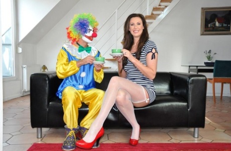 Зрелая дама занимается сексом с клоуном в нейлоновых чулках и подвязках 2