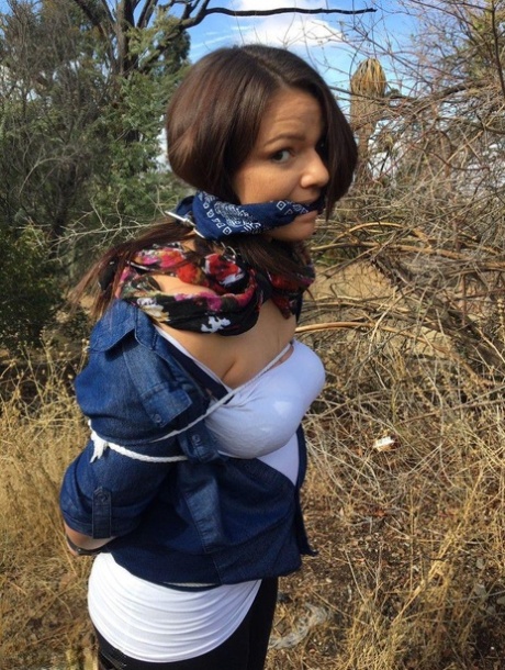 Полностью одетый толстяк расколот, с кляпом во рту и связанный веревкой в заросшем кустарником лесу 12